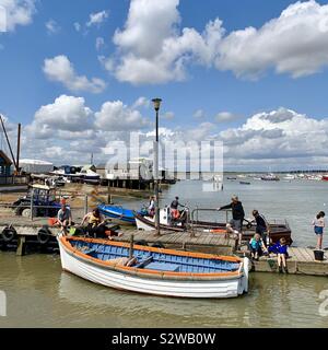 Felixstowe Ferry, Suffolk, Regno Unito - 19 August 2019: persone attività di pesca del granchio dal molo sul Fiume Deben. Foto Stock