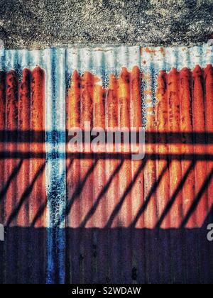 Ombra di ringhiere su un ferro corrugato tetto. Foto Stock
