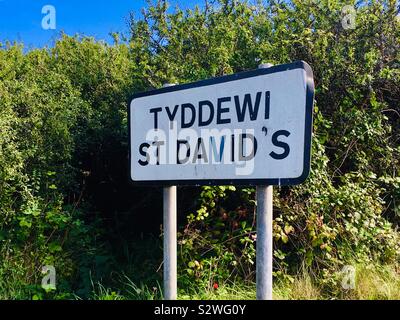 Bilingual cartello stradale per St David's in Pembrokeshire, West Wales. Inglese e lingua gallese Foto Stock