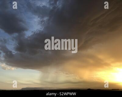 Monsoon pioggia cade al di sopra del Superstition Mountains in Arizona a sunrise Foto Stock