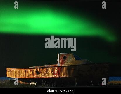 Aurora boreale, luci del nord e la vecchia barca da pesca a Churchill, Manitoba, Canada sulle rive della Baia di Hudson Foto Stock