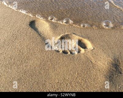 Singola impronta umana sulla spiaggia sabbiosa Foto Stock