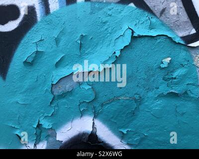 Strati di vernice vecchia spellatura di graffiti su un muro di cemento formando un abstract Foto Stock