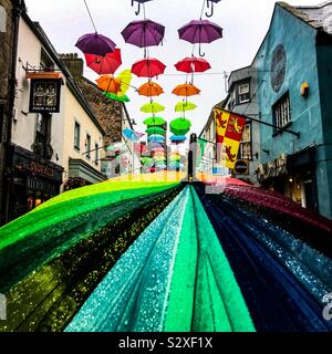 Guardando oltre la sommità di un pedone portati ombrello coloratissimo fino Palace Street a Caernarfon Galles del Nord a 170 brolly arte di installazione da Hwb Caernarfon Foto Stock