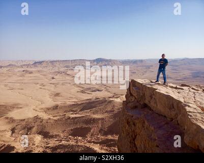 Un turista in piedi dal cratere di Ramon in Israele. Foto Stock