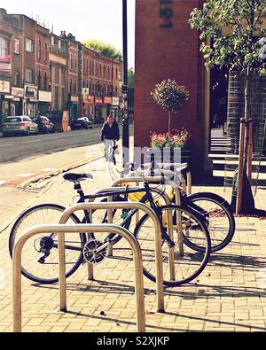 Le biciclette parcheggiate a rack su una strada per lo shopping Foto Stock