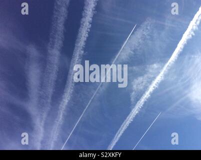 Molti contrails o vapore sentieri nel cielo da diversi piani di jet nel cielo Foto Stock