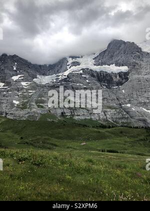 Montagna a freddo con il ghiaccio in inverno e sotto un prato verde Foto Stock