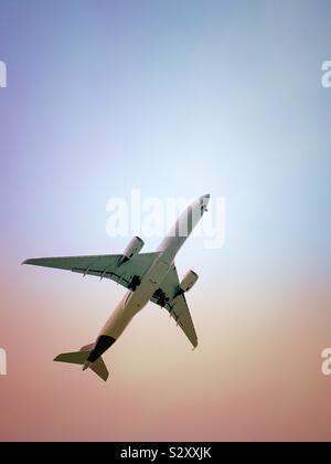 Aereo che vola fotografato dal basso con cielo color pastello. Spazio per la copia. Foto Stock