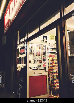 Una licenza negozio di bevande durante la notte con le luci e la porta anteriore aperta, nel Regno Unito Foto Stock