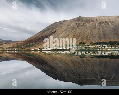 Isafjordur, Islanda - Settembre 2019: Riflessioni nel porto ancora acqua su una mattina nuvoloso nei Fiordi Occidentali. Foto Stock