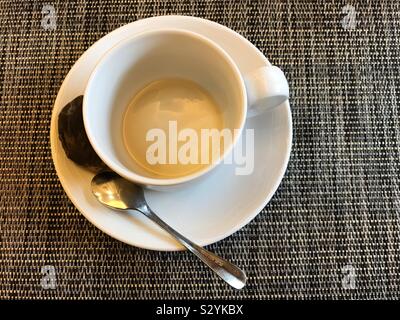 Svuotare tazza da caffè con piattino usato con bustine di the e cucchiaino. Foto Stock