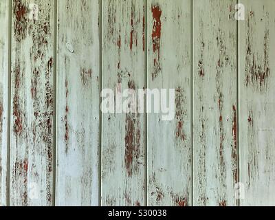 Vecchio, distressed parete in legno in un pastello blu il colore verde con peeling vernice all'interno di un edificio abbandonato. Foto Stock