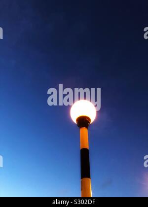 Belisha beacon lampeggiare al crepuscolo Foto Stock