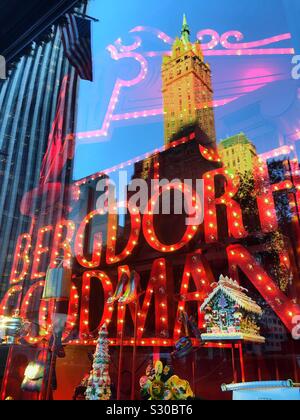 Riflessioni di grattacieli in vacanze di Natale di windows a Bergdorf Goodman, un department store sulla Fifth Avenue a Manhattan, New York City, Stati Uniti d'America Foto Stock