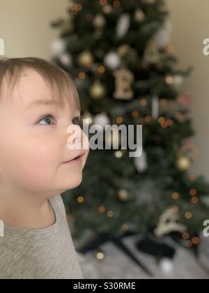 La mia splendida ragazzino di fronte all'albero di Natale Foto Stock