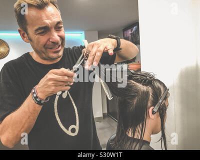 Parrucchiere il taglio di una giovane donna capelli Foto Stock