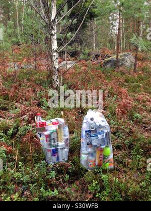 Due grandi sacchi pieni di plastica le bottiglie in PET e lattine di alluminio da riciclare, circondato da foresta rurale a Stoccolma, Svezia Foto Stock