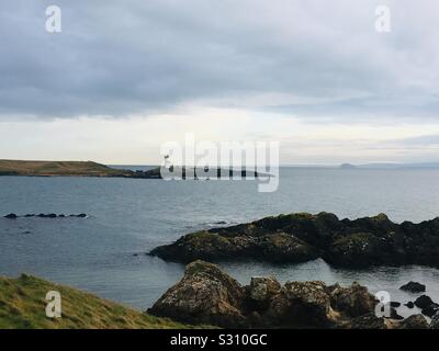 Guardando attraverso la caletta rocciosa di Elie Ness faro sul Firth of Forth, East Neuk, Scozia Foto Stock