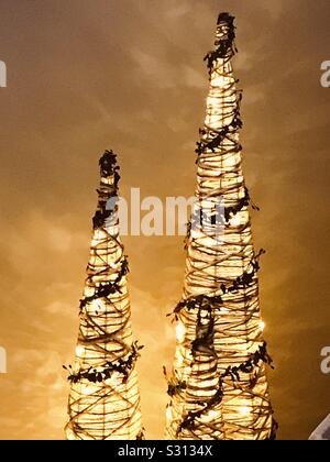 Albero di Natale decorazioni di cono con le luci fairy riflettendo sulla parete Foto Stock