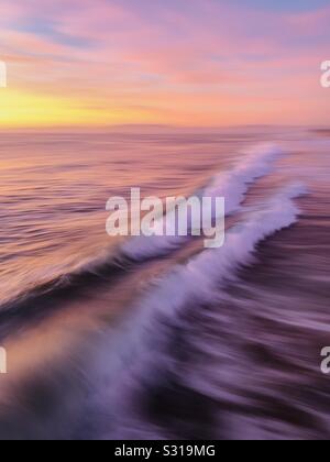Foto artistiche di sfocatura di onde che si infrangono nell'oceano al tramonto. Manhattan Beach, California USA. Foto Stock