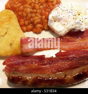 Piatto di cibo per la colazione con uova di pancetta fagioli cotti e. crocchette di hash Foto Stock