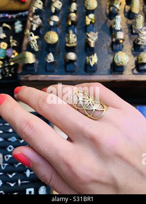 Cercando su un seme di vita anello in corrispondenza di una pressione di stallo di gioielli con anello di visualizzazione in background Foto Stock