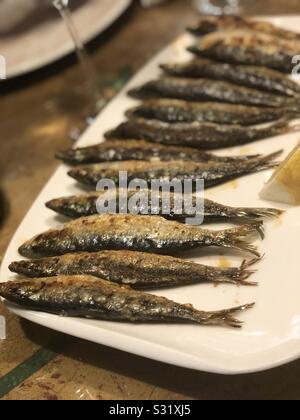 Piastra con profonda le sardine fritte e limone Foto Stock