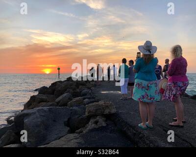 Un gruppo di persone si è riunito e guardando il tramonto a Sarasota, Florida, Stati Uniti. Foto Stock