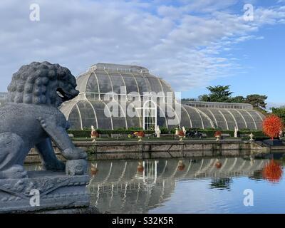 Palm House con vetro chihuly e leone di pietra a Kew Gardens, Londra Foto Stock