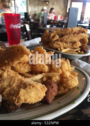 Pesce fritto e gamberetti, cuccioli di fush e patatine fritte su un piatto al ristorante Pierre Maspero nel quartiere francese di New Orleans, Louisiana, Stati Uniti. Foto Stock