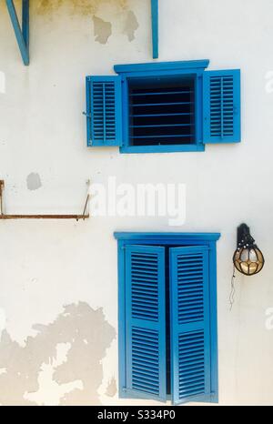 Finestre blu in stile mediterraneo che decorano una vecchia casa a Jaffa, Israele. Foto Stock
