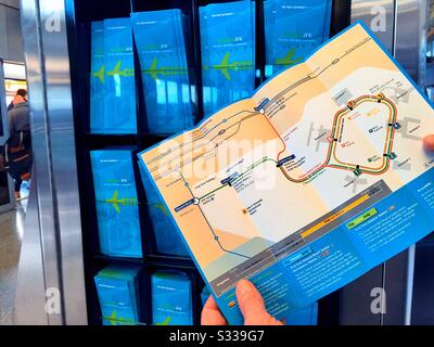 L'uomo caucasico che legge un opuscolo della mappa del percorso dell'airtrain aggiunge una stazione terminale all'aeroporto JFK a New York City USA Foto Stock