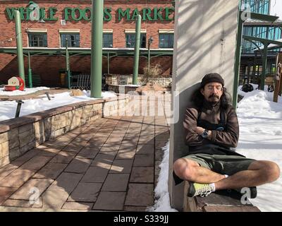 Un membro del team Whole Foods si prende un pisolino al sole in pausa davanti a un negozio Whole Foods Market di Boulder, Colorado. Foto Stock