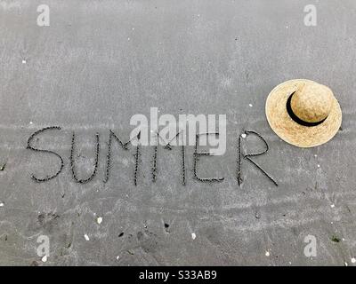 Estate scritta sulla sabbia vicino a un cappello Foto Stock