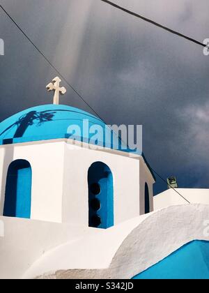 Un raggio di sole splende in una croce su un tetto blu di una chiesa ortodossa greca sull'isola greca di Naxos Foto Stock