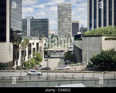 LOS ANGELES, CA, 2020 FEBBRAIO: Guardando a nord lungo Flower St nel centro città, traffico sulle strade in primo piano, uffici e montagne dietro Foto Stock