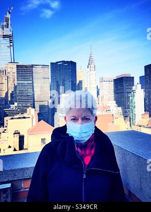 La donna anziana con problemi di salute e sicurezza indossa un facemask protettivo nel centro di Manhattan durante la pandemia COVID-19, New York City, USA Foto Stock