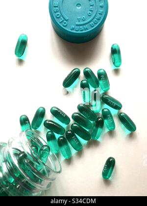 Capsule di ibuprofene versate su una superficie bianca, vista dall'alto verso il basso Foto Stock