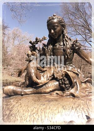 La scultura di Alice in Wonderland nel parco centrale è circondata da ciliegi in fiore in primavera, NYC, Stati Uniti Foto Stock