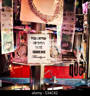 Vista ravvicinata di un cartello e premi in denaro in una macchina arcade in una fiera in viaggio Foto Stock