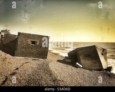 Colonne di cemento in tempo di guerra sulla spiaggia a causa dell'erosione costiera, Bawdsey, Suffolk, Inghilterra. Foto Stock