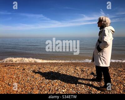 Donna nel suo anni '70 sociale di distanza dal mare Foto Stock
