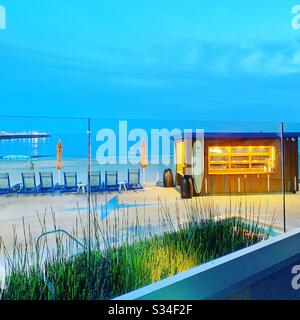 Una vista serale davanti alla vasca idromassaggio e al bar della piscina verso l'oceano al Dream Inn Santa Cruz, Santa Cruz, California, Stati Uniti Foto Stock