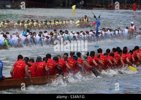 Dragon Boat Festival nel 2019, tre squadre che corrono fino al traguardo all'altra estremità del porto di Aberdeen, Hong Kong Foto Stock