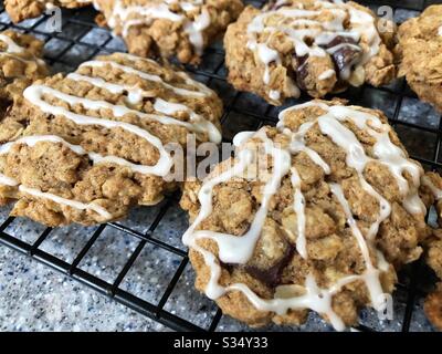 Biscotti ghiacciati alla farina d'avena con blocchi di cioccolato che si raffreddano su un rack. Foto Stock