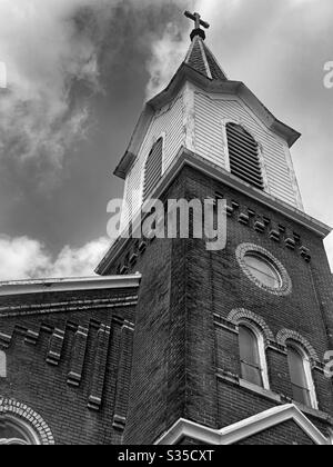 DUBUQUE, IOWA, 17 aprile 2020 – Foto di paesaggio bianco e nero di una bella chiesa di mattoni in una piccola città nel Midwest, nella nuvolosa giornata primaverile. Foto Stock