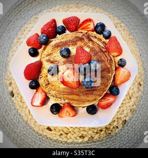 Pancake alla banana conditi con mirtilli e fragole Foto Stock