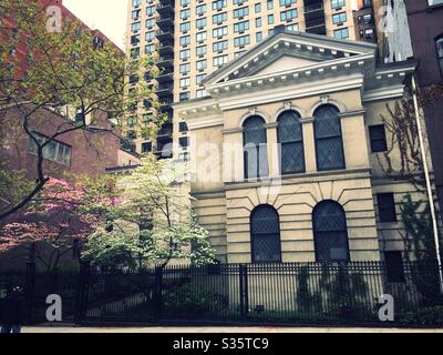 La chiesa comunitaria di New York Unitarian Universalist al 40 E. 35th St. A Murray Hill, NYC, USA è circondata da alberi di dogwood fiorenti in primavera Foto Stock