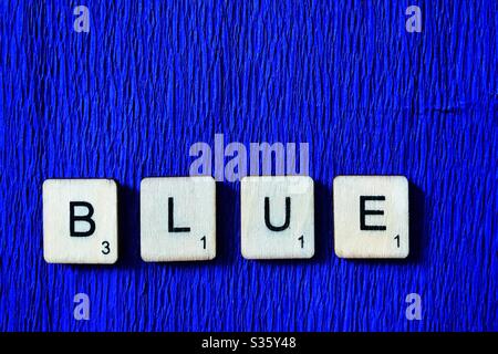 Le piastrelle di legno si spell out blu su sfondo blu. Foto Stock